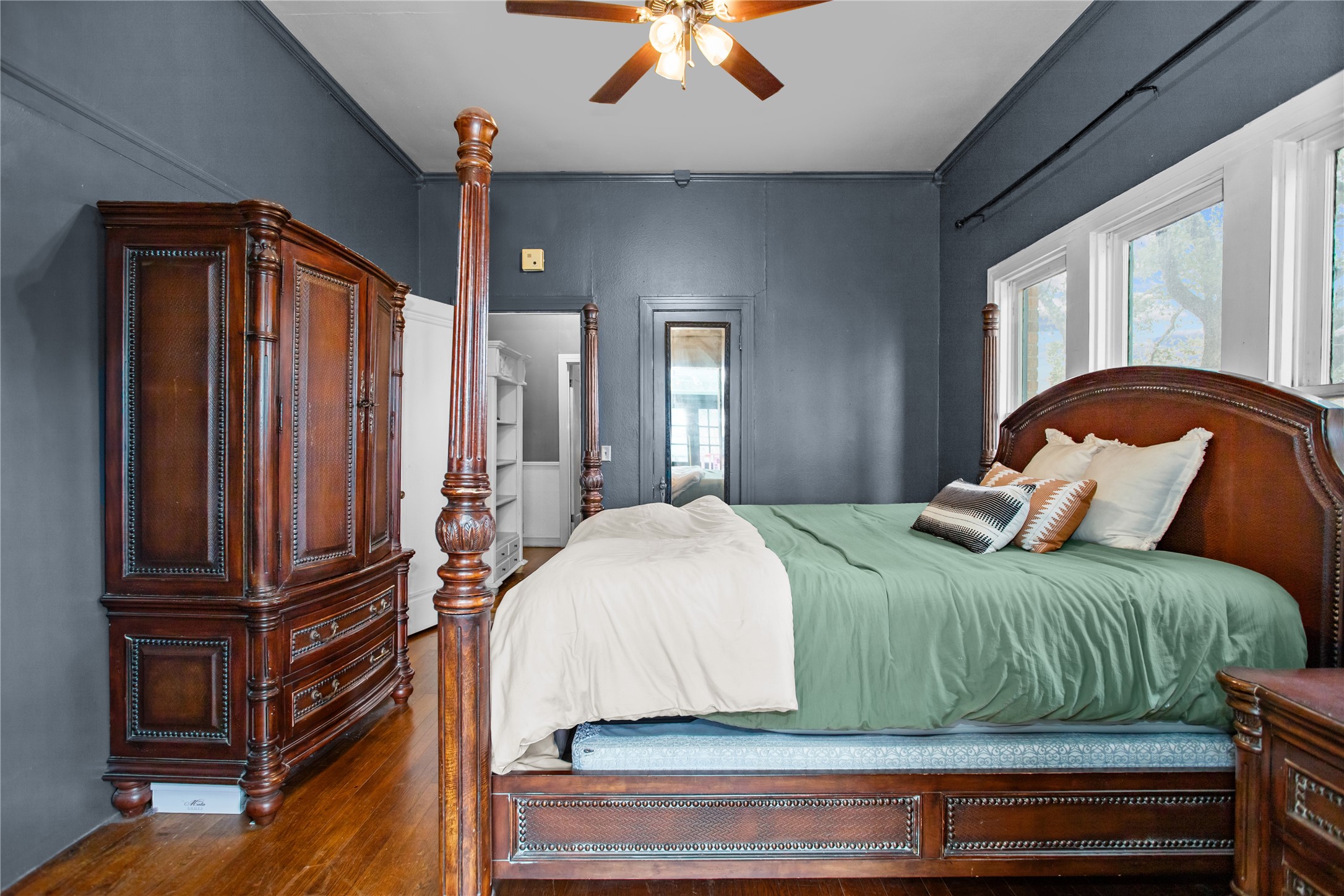 706 East Main Street Madisonville, TX 77864 - Photo 19 of 25 a bedroom with a bed and dresser with wooden floor