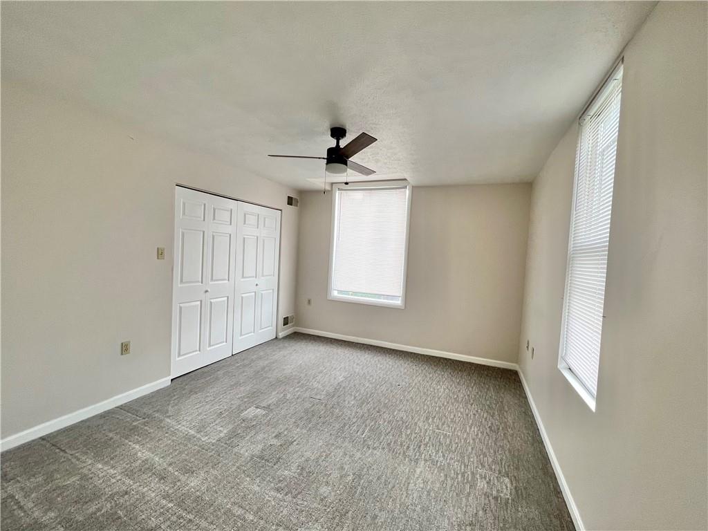 124 Virginia Avenue, Unit 2 Mount Washington, PA 15211 - Photo 7 of 11 an empty room with windows and a ceiling fan
