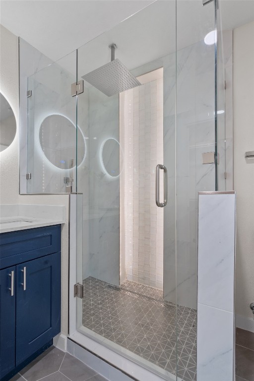 6901 Windrift Way Austin, TX 78745 - Photo 22 of 30 Bathroom with dark tile patterned floors, a marble finish shower, and vanity