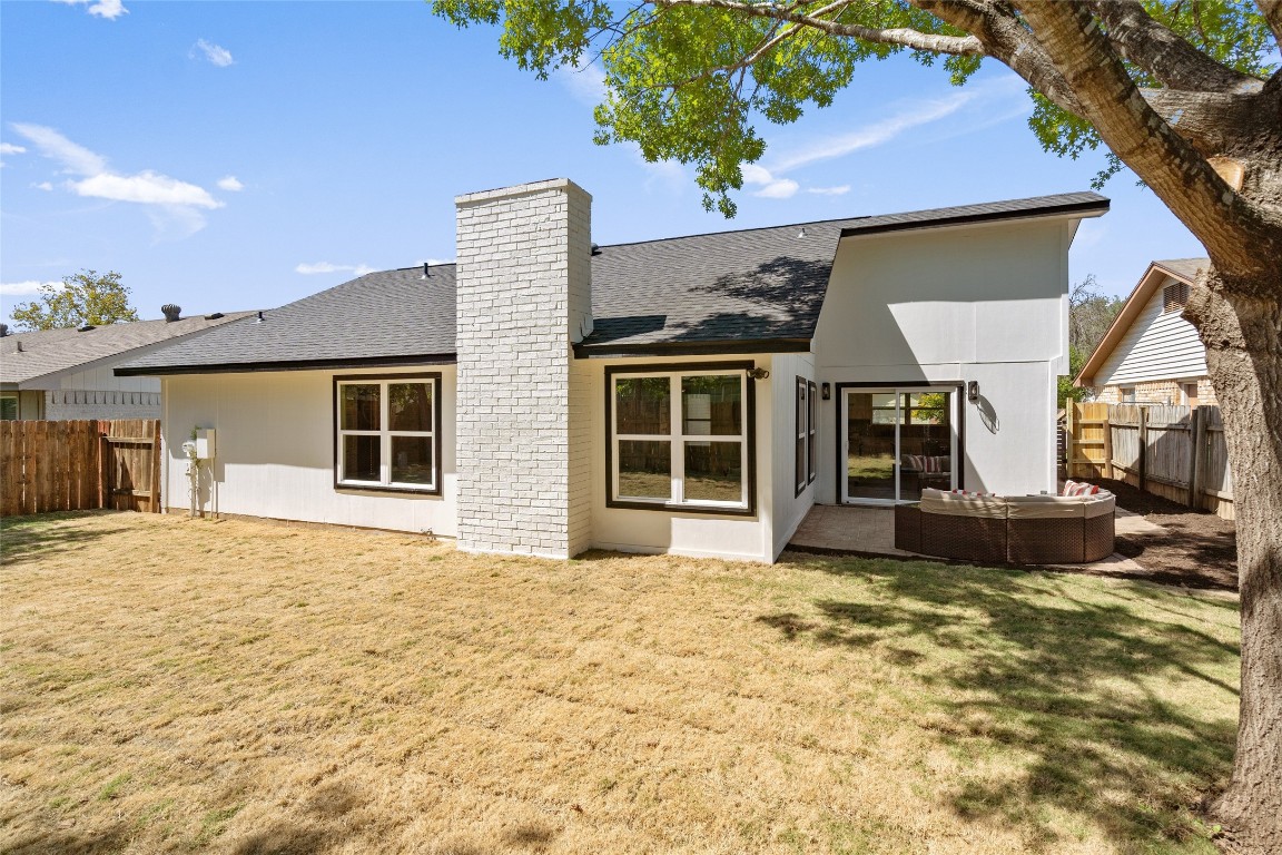 6901 Windrift Way Austin, TX 78745 - Photo 29 of 30 Rear view of property featuring a fenced backyard, roof with shingles, a patio, and a chimney