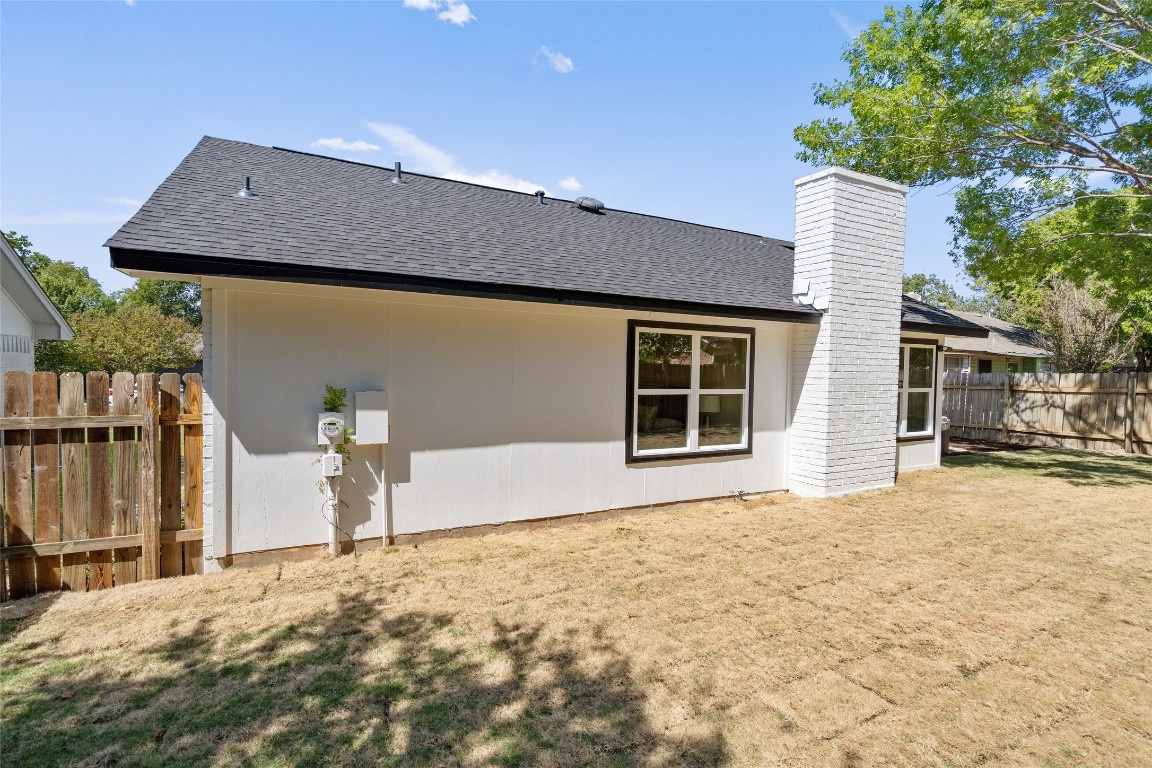 6901 Windrift Way Austin, TX 78745 - Photo 30 of 30 Back of house featuring a shingled roof and a chimney