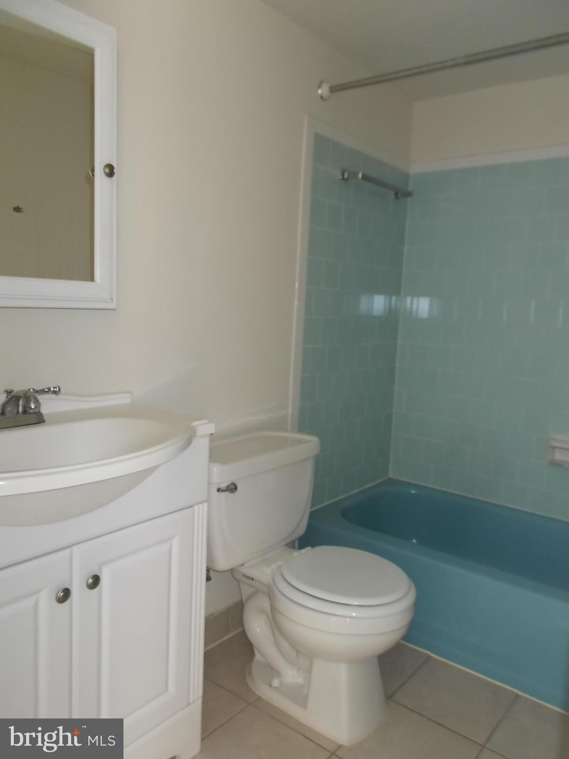 3934 Bel Pre Road, Unit 6 Silver Spring, MD 20906 - Photo 14 of 16 a bathroom with a toilet a sink a shower and a mirror