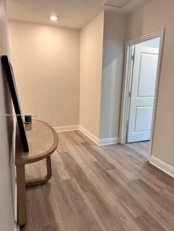 a view of a hallway with wooden floor and staircase
