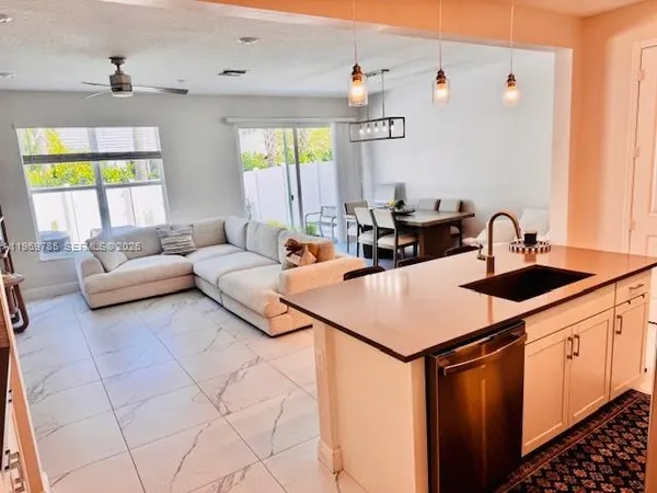 a kitchen with stainless steel appliances a sink a stove a chimney and a refrigerator