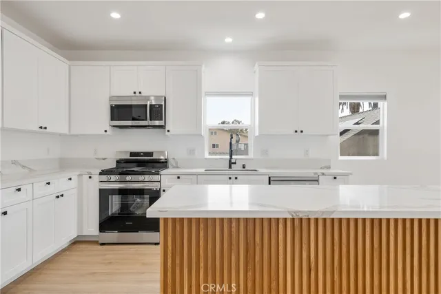 a kitchen with granite countertop white cabinets and white appliances