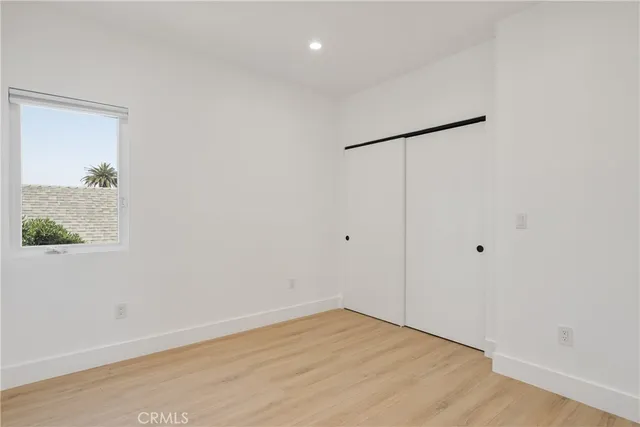 an empty room with wooden floor and a window