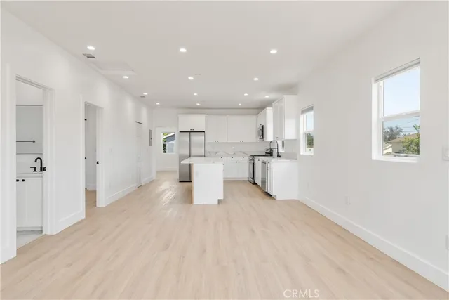 a kitchen with stainless steel appliances a stove a sink a microwave and wooden cabinets