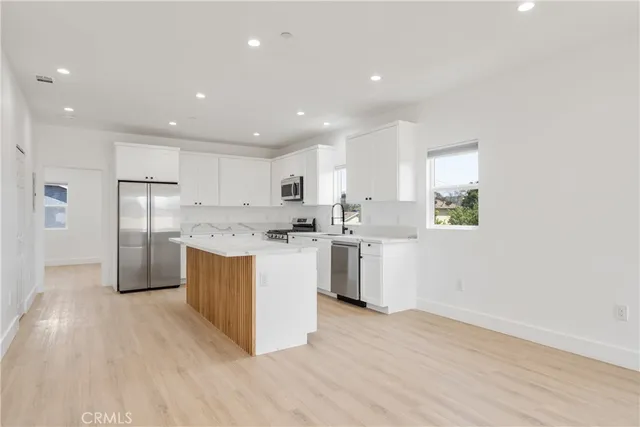 a kitchen with granite countertop white cabinets and window