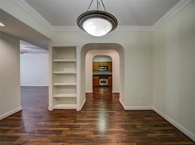 a view of empty room with wooden floor and window