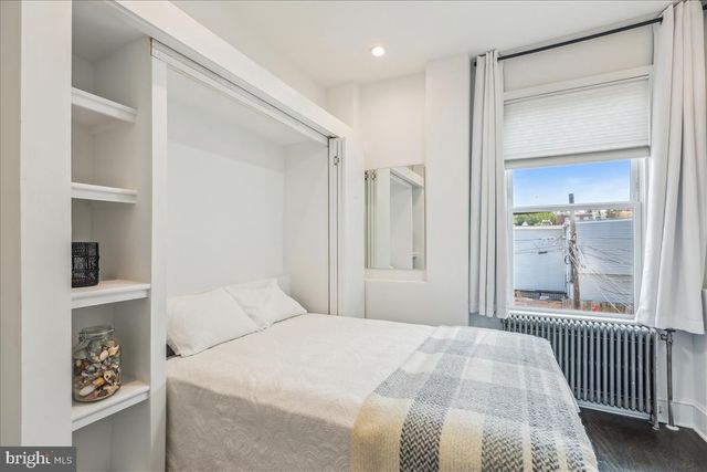 a bedroom with a bed and a painting on the wall