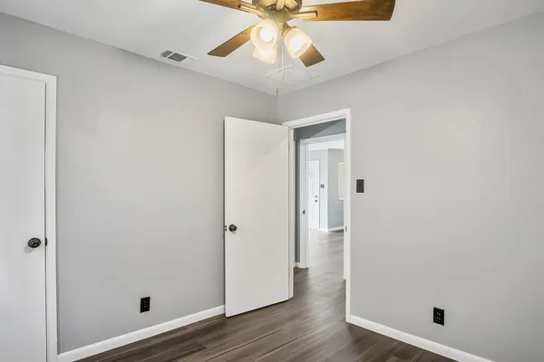 a view of an empty room with wooden floor