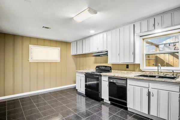 a kitchen with stainless steel appliances a stove a sink a microwave and cabinets