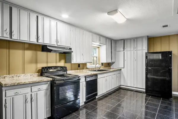 a kitchen with a stove a sink and a refrigerator