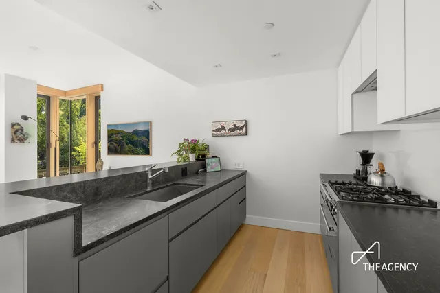 a kitchen with stainless steel appliances a table and chairs in it