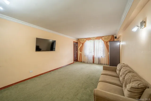 a living room with a flat screen tv a lamp and a window