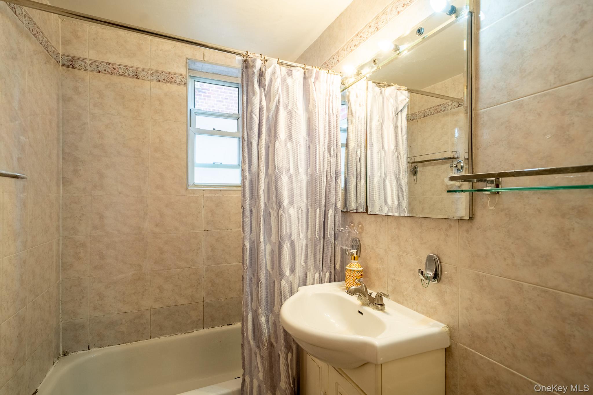 62-59 108th Street, Unit 4N Queens, NY 11375 - Photo 9 of 10 a bathroom with a sink a mirror and a shower