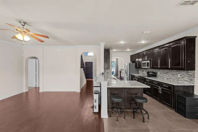 a living room with stainless steel appliances kitchen island furniture and a fireplace