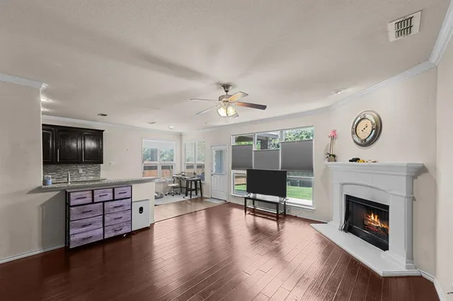 an empty room with wooden floor fireplace and windows