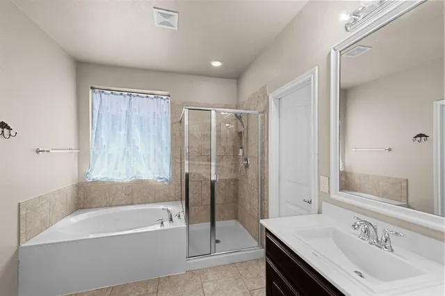 a bathroom with a granite countertop bathtub shower sink vanity and mirror