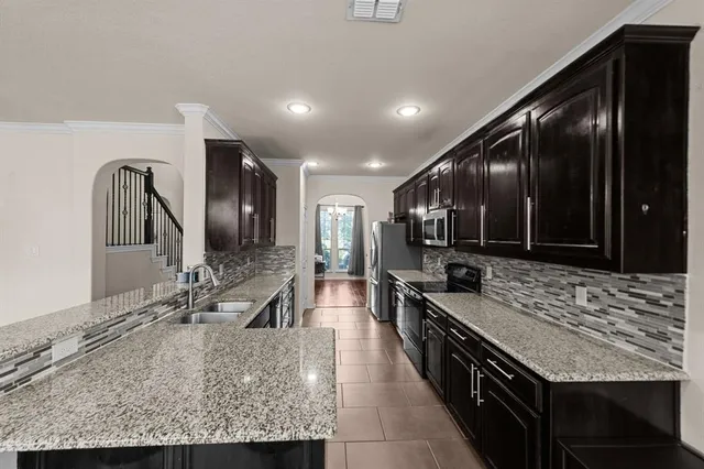 a large kitchen with granite countertop a large stove and cabinets