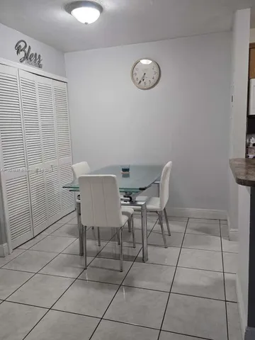 a room with furniture a flat screen tv and kitchen view