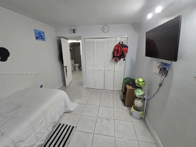 a bedroom with a bed and a view of kitchen