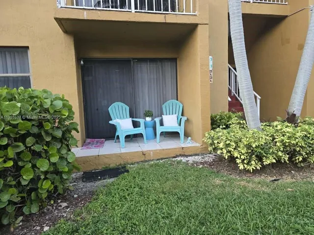 a view of a chair and table in back yard of the house
