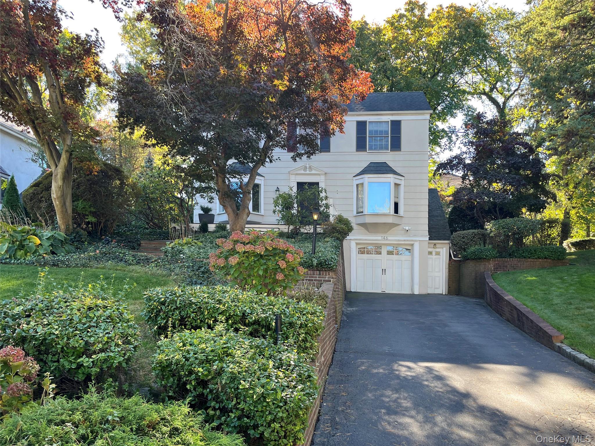 Colonial inspired home with asphalt driveway and an attached garage