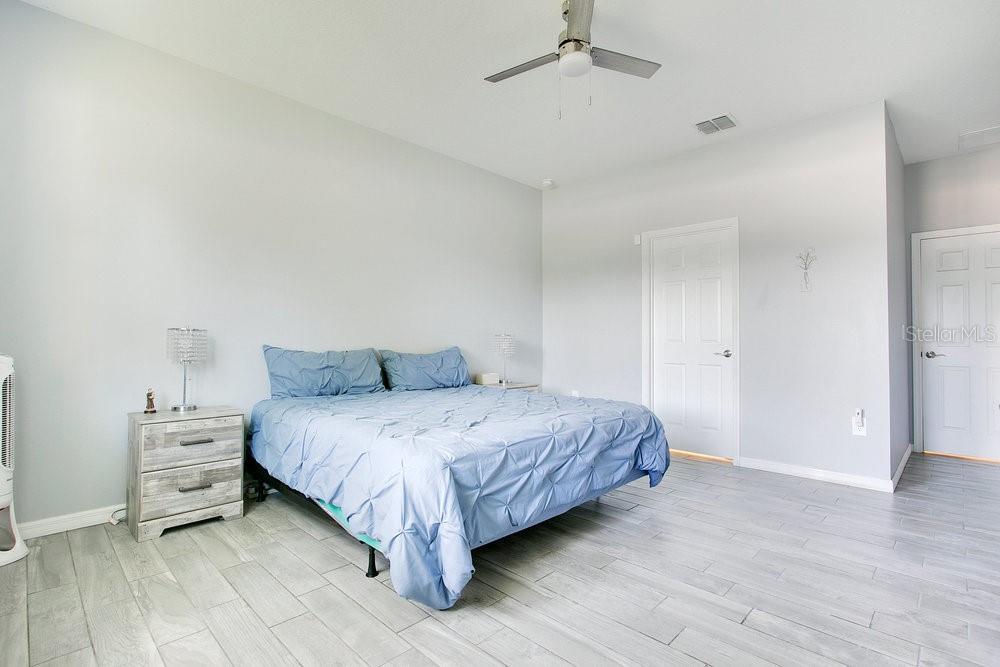 3964 Mayhill Loop Eustis, FL 32736 - Photo 14 of 34 a bedroom with a bed and a chandelier