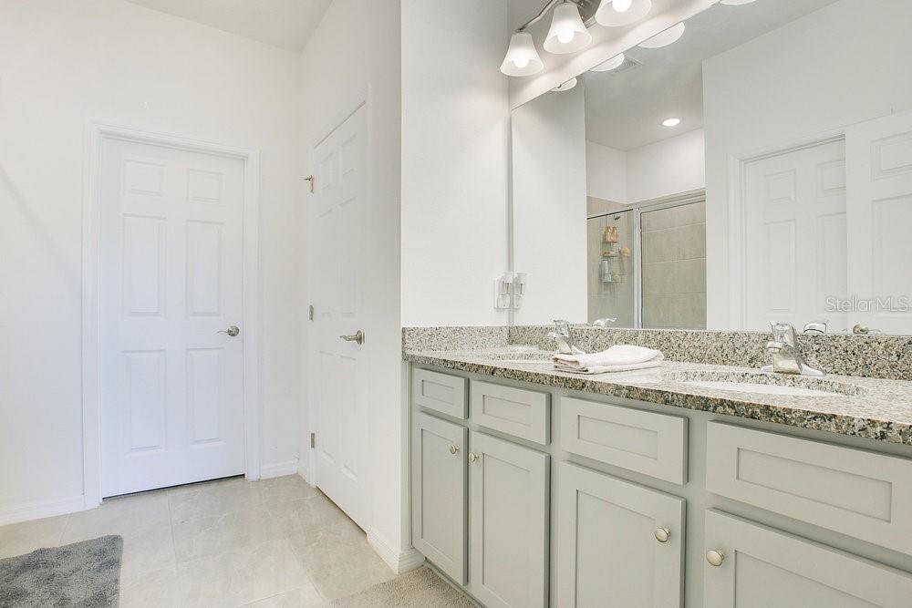 3964 Mayhill Loop Eustis, FL 32736 - Photo 15 of 34 a bathroom with a granite countertop sink and a mirror