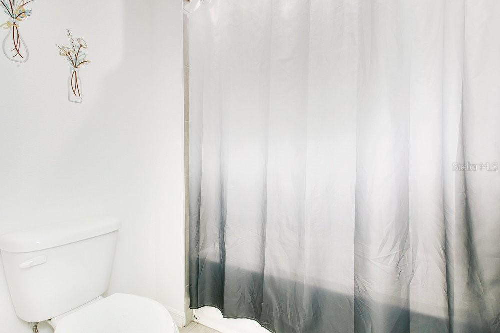 3964 Mayhill Loop Eustis, FL 32736 - Photo 21 of 34 a white toilet sitting next to a shower curtain