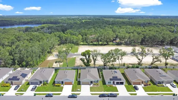 an aerial view of residential houses with outdoor space and swimming pool