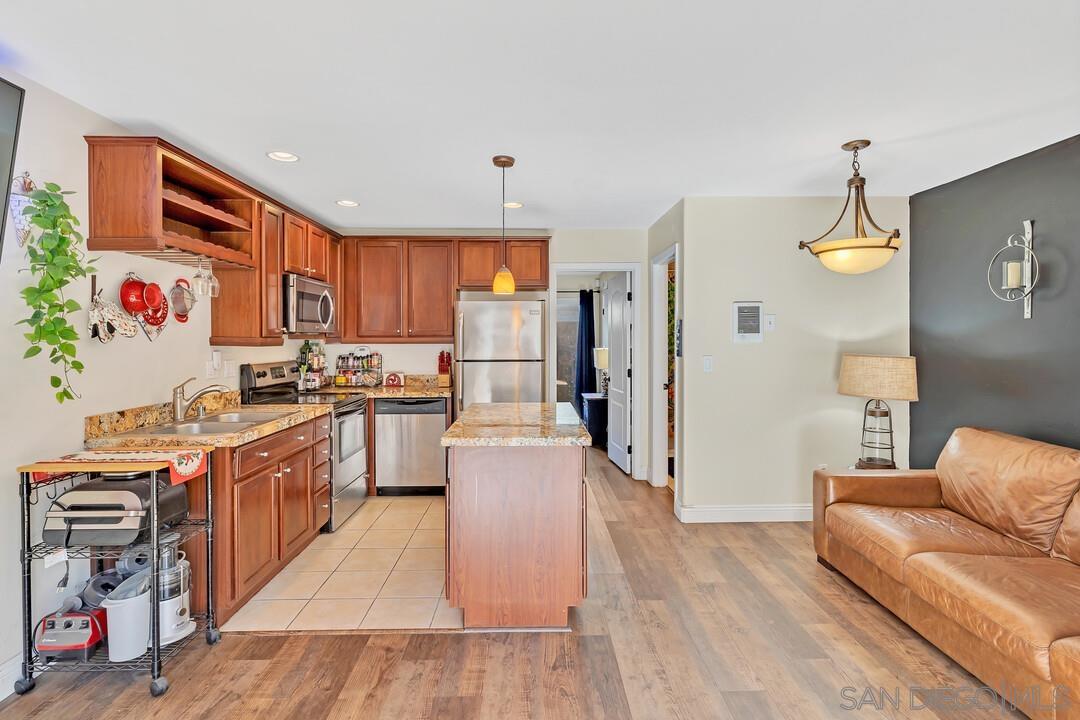 a kitchen with stainless steel appliances granite countertop a refrigerator a stove top oven and a sink