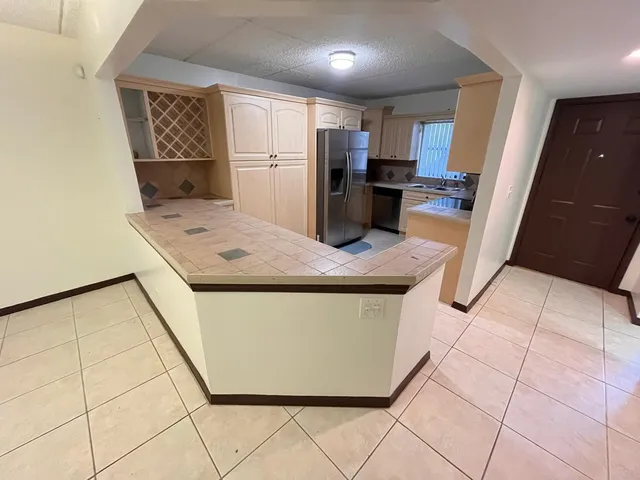 a kitchen with stainless steel appliances granite countertop a sink a refrigerator and a stove