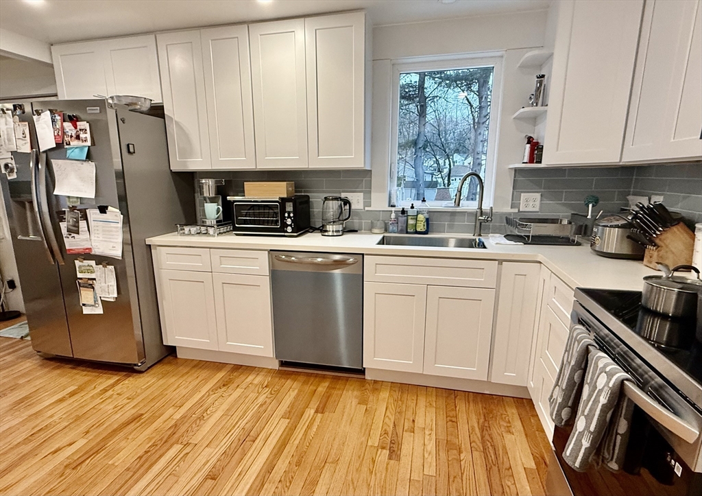 20 Alma Road Burlington, MA 01803 - Photo 2 of 26 a kitchen with stainless steel appliances granite countertop a stove a sink dishwasher and a refrigerator with wooden floor
