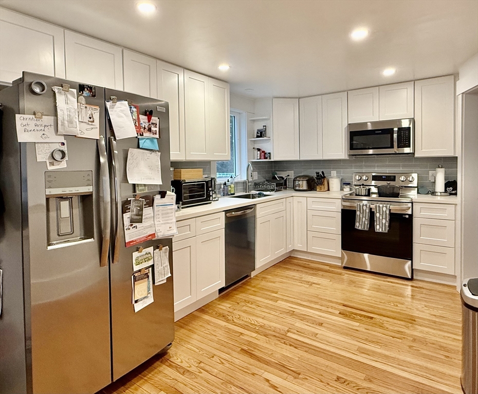 20 Alma Road Burlington, MA 01803 - Photo 3 of 26 a kitchen with stainless steel appliances granite countertop a stove top oven a refrigerator a sink and dishwasher with white cabinets