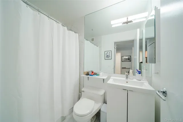 a bathroom with a sink vanity mirror and toilet