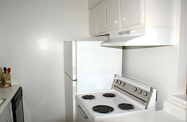 a kitchen with a refrigerator and a stove