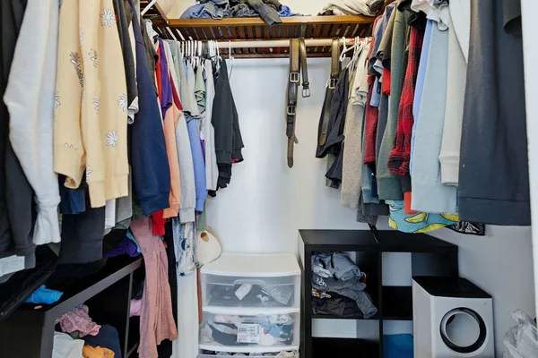 a view of walk in closet with clothes and shoes