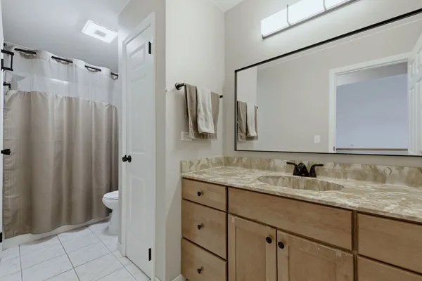 a bathroom with a granite countertop sink toilet and shower