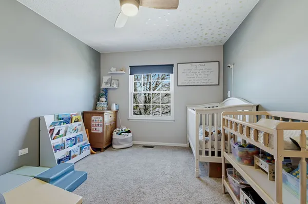 a bedroom with furniture and baby crib