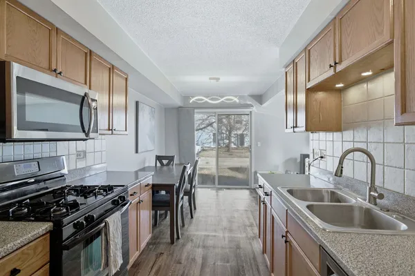 a kitchen with granite countertop a sink stove and refrigerator