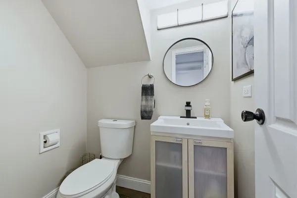 a bathroom with a toilet a sink and mirror