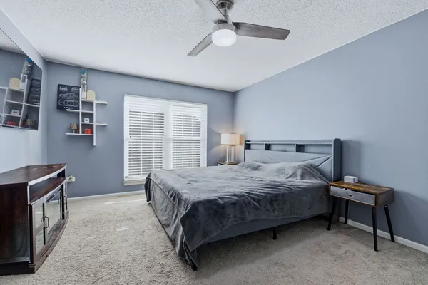 a spacious bedroom with a bed and a window