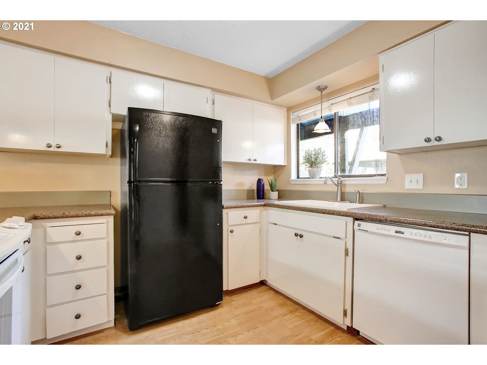 10237 Southwest Denney Road Beaverton, OR 97008 - Photo 19 of 32 a kitchen with a refrigerator and white cabinets