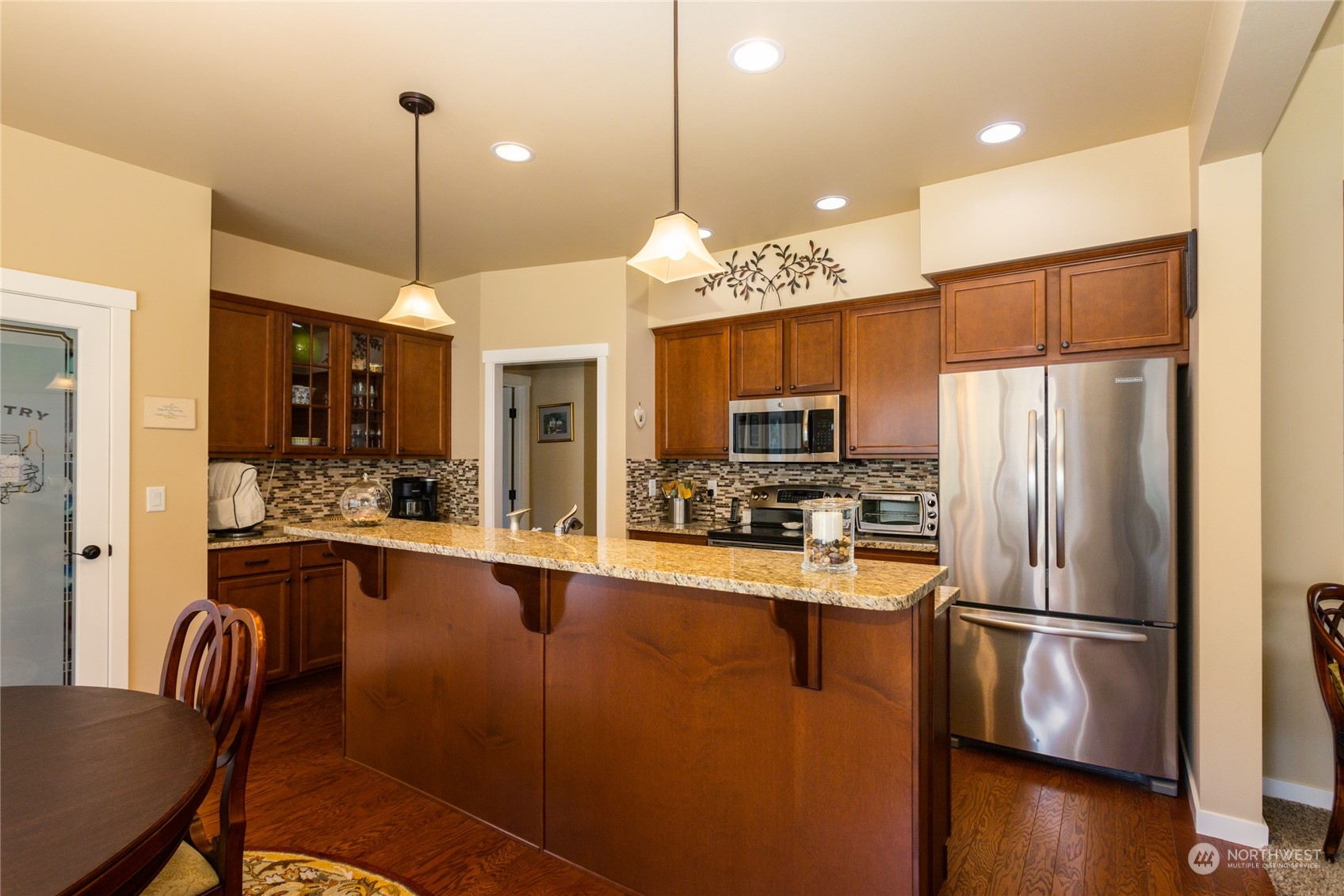 1563 Bryce Park Loop Lynden, WA 98264 - Photo 8 of 32 a kitchen with stainless steel appliances a refrigerator a sink a stove a dining table and chairs