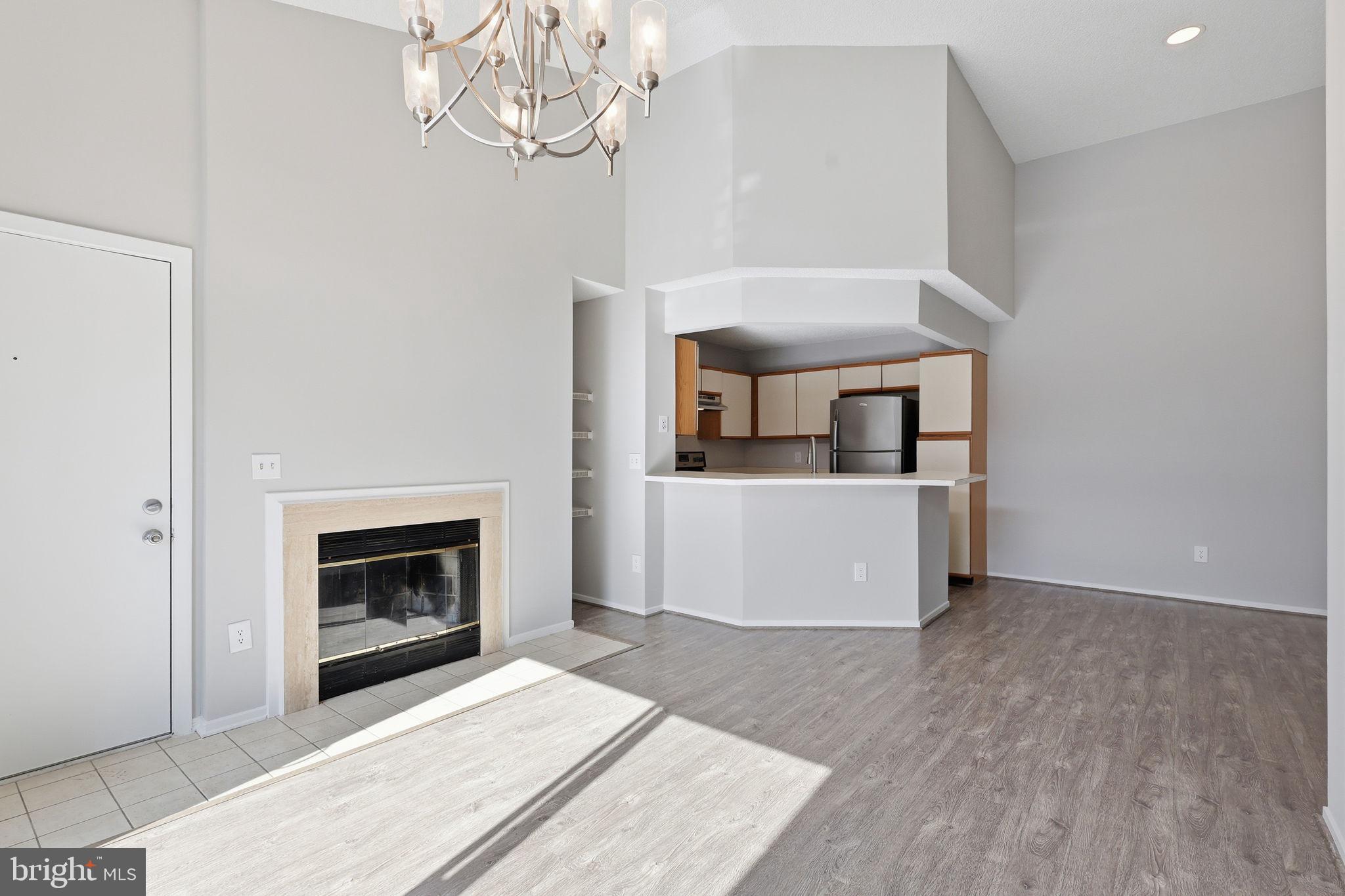 1508 Summerchase Court Reston, VA 20194 - Photo 7 of 23 a living room with a fireplace furniture a rug and a chandelier