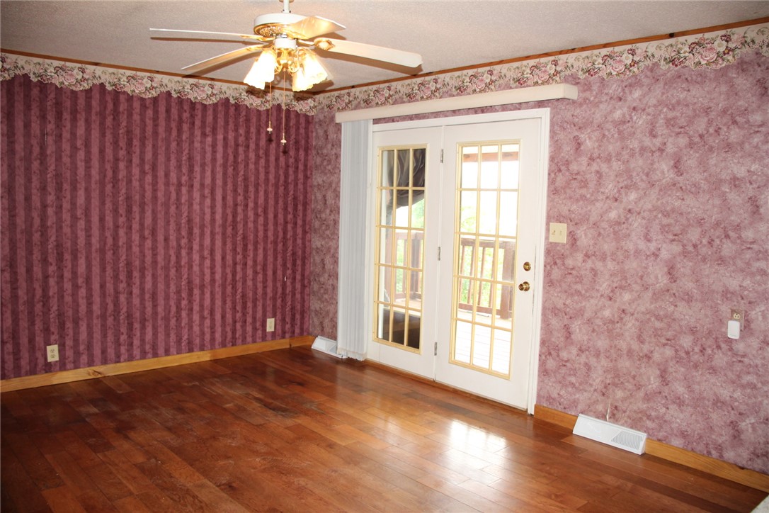 402 Canaan Road Marshall, AR 72650 - Photo 15 of 37 Rich wood-finish flooring complements this room featuring white French doors