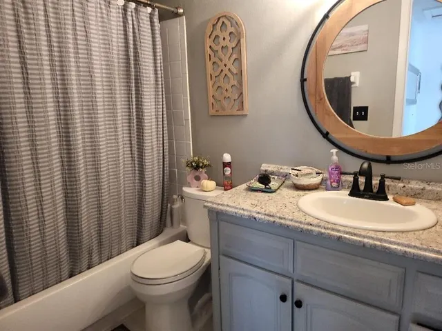 a bathroom with a granite countertop sink mirror and toilet