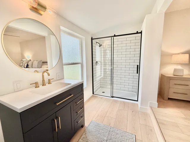 a bathroom with a sink vanity granite and a mirror